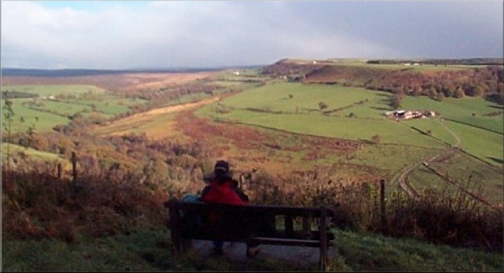 Enjoying the view from the seat on the edge of the car park at the top of Cow House Bank