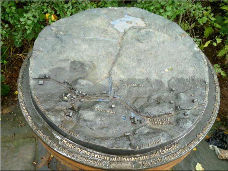 Cast metal relief map of the site set on a large wooden bobbin in the car park