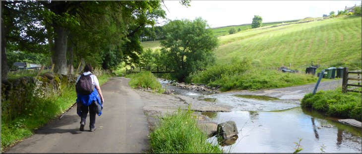 The road turns sharp right here and crosses the ford over the River East Allen. Ahead is a stony farm access track
