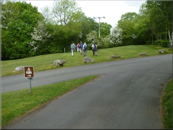 Turning off the access road to the path by the boundary hedge