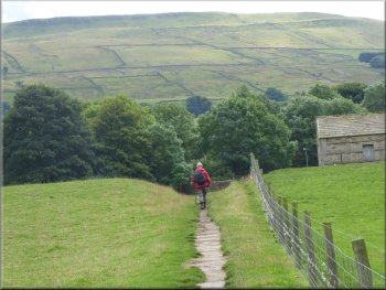 Paved path of the Pennine Way heading back into Hawes