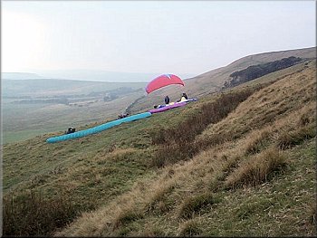 Paragliding enthusiasts waiting for the wind on Rushup Edge
