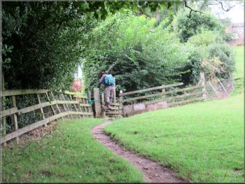 Stile to a little footbridge & a passage between the gardens