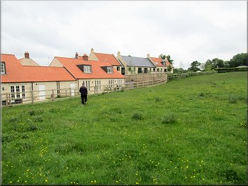 Path along the field edge with new housing over the fence
